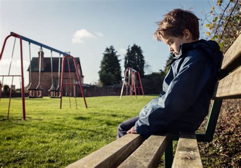 Lonely child sitting on play park playground bench - Sensory Stepping ...