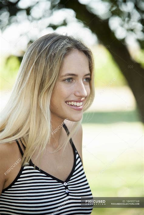 Portrait of smiling blonde woman looking away outdoors — person, 20 25 ...