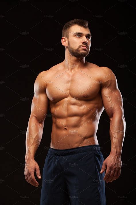 Fitness muscular man is posing and showing his torso with six pack abs ...