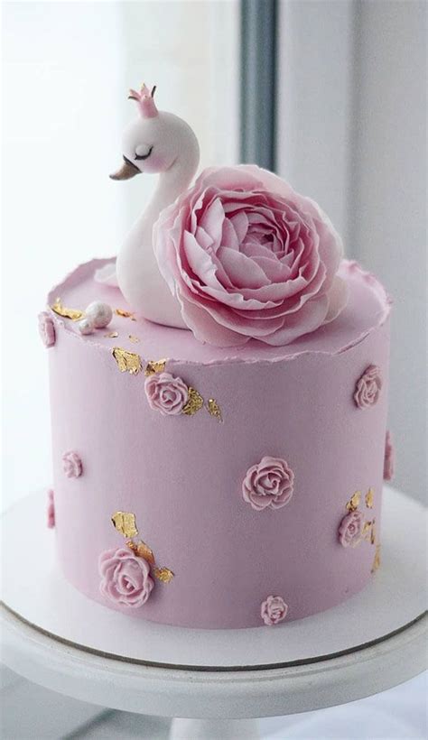 a pink cake decorated with flowers and a white swan