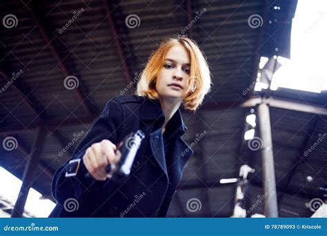 Woman pointing gun at goldfish stock photo - rillypolice