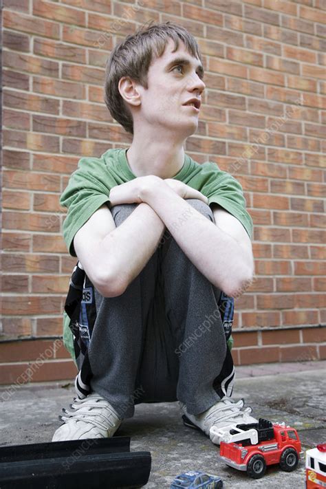 Teenage boy with autism playing with toy vehicles - Stock Image - C046 ...