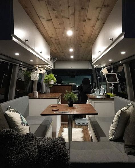 the interior of an rv with couches, tables and lamps on it's ceiling