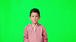 Face, green screen and boy with arms crossed, angry and frustrated against studio background. Portrait, male child or kid with anger, grumpy or attitude problem with facial expression and frustration