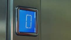 Pressing button on elevator panel.