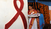 An Indian volunteer passes by an AIDS symbol